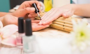 Nail technician giving customer a manicure at the beauty salon